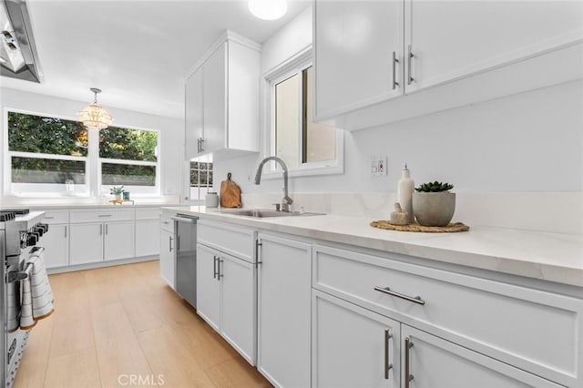 6454 Baird Ave, Reseda, CA 91335 - kitchen featuring a sink, appliances with stainless steel finishes, white cabinetry, light wood-type flooring, and light stone countertops