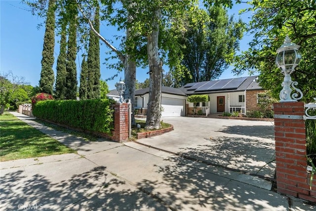 6454 Baird Ave, Reseda, CA 91335 - view of front of house with driveway, solar panels, a garage, a porch, and fence