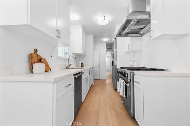 6454 Baird Ave, Reseda, CA 91335 - kitchen with a sink, wall chimney range hood, appliances with stainless steel finishes, white cabinetry, and light wood-style floors