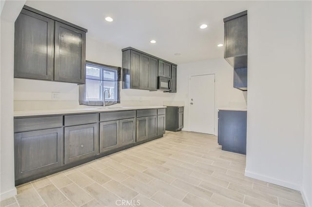 343 E 98th St, Los Angeles, CA 90003 - kitchen with black microwave, a sink, light countertops, recessed lighting, and baseboards