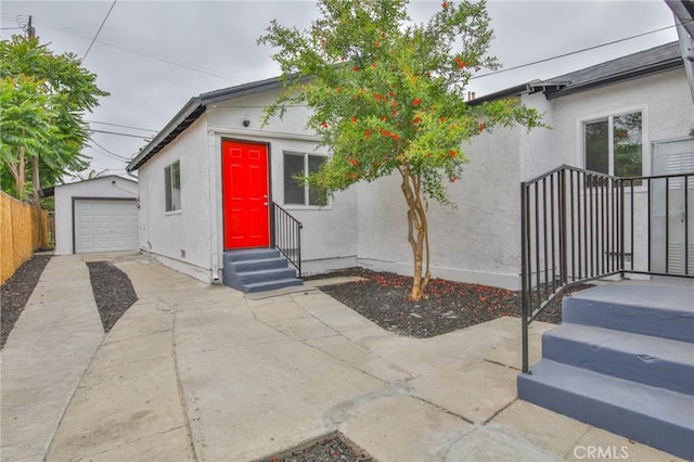 343 E 98th St, Los Angeles, CA 90003 - view of front of home with stucco siding, an outdoor structure, concrete driveway, and entry steps