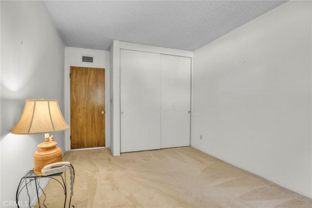 bedroom featuring carpet floors, a closet, and a textured ceiling