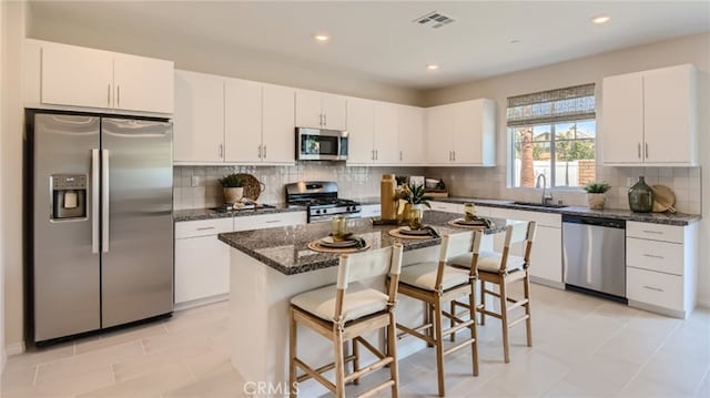 30031 Adrift Ln, Menifee, CA 92584 - kitchen featuring appliances with stainless steel finishes, a sink, a breakfast bar, white cabinets, and recessed lighting