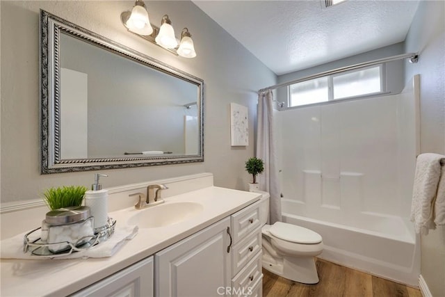 bathroom with toilet, wood finished floors, shower / tub combo, and vanity