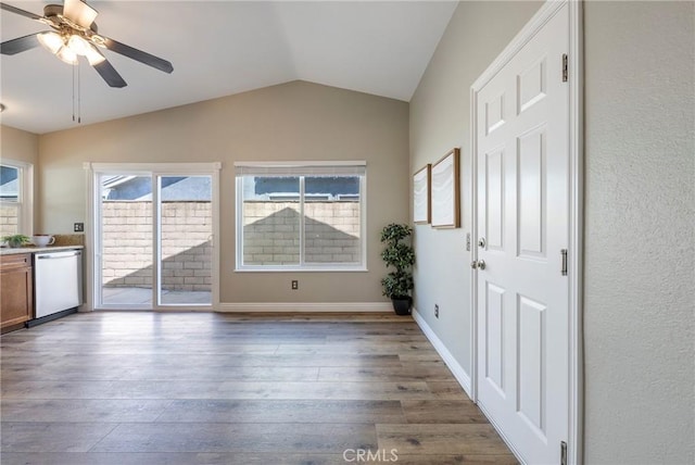 foyer featuring vaulted ceiling, wood finished floors, a ceiling fan, and baseboards