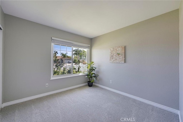 carpeted empty room with baseboards