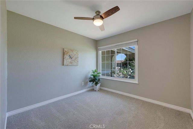 empty room featuring carpet, baseboards, and a ceiling fan