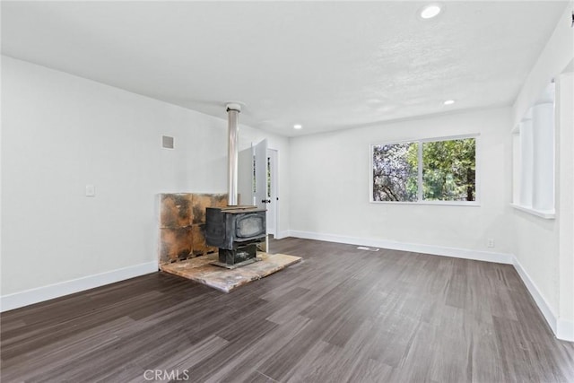 82 Dedeker Ln, Oroville, CA 95966 - unfurnished living room featuring a wood stove, dark wood-style floors, baseboards, and recessed lighting