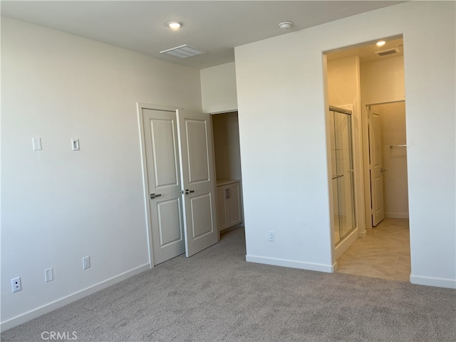 unfurnished bedroom with carpet flooring, baseboards, and a walk in closet