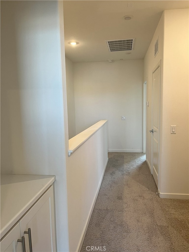 hall featuring light carpet, baseboards, and recessed lighting