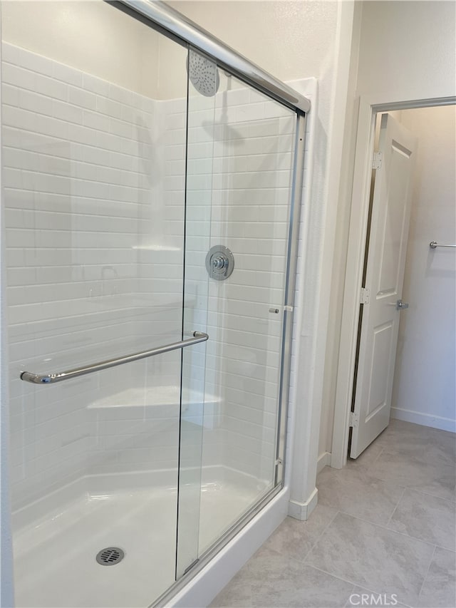 full bathroom featuring a stall shower, baseboards, and tile patterned floors
