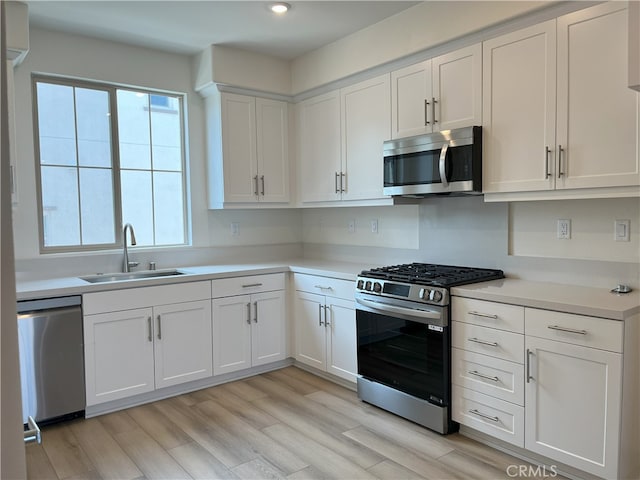 kitchen featuring appliances with stainless steel finishes, light countertops, white cabinets, and recessed lighting