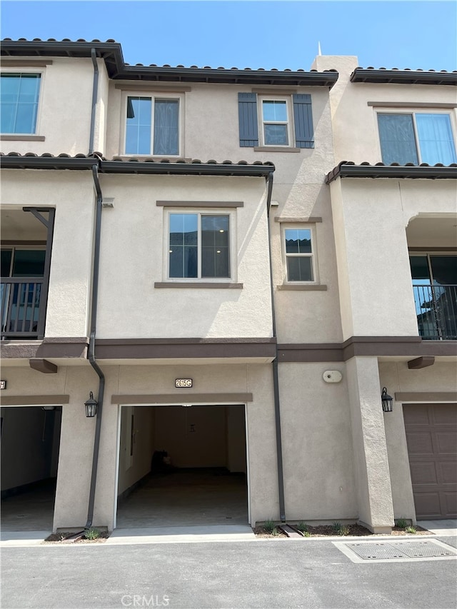 rear view of property featuring stucco siding and an attached garage