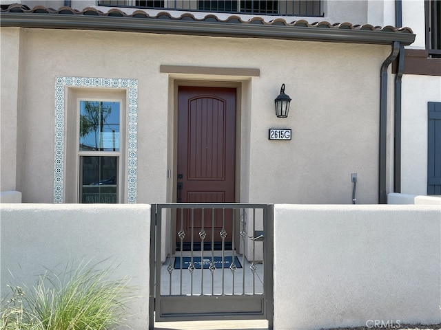 property entrance with stucco siding and a tiled roof