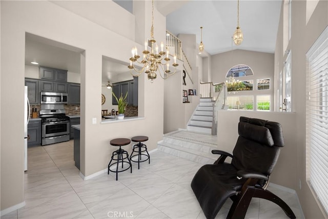 sitting room featuring a chandelier, stairs, baseboards, and high vaulted ceiling