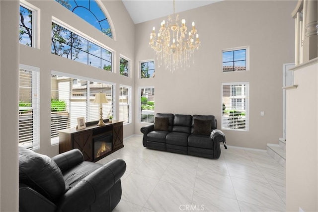 tiled living area featuring high vaulted ceiling, plenty of natural light, baseboards, and a chandelier