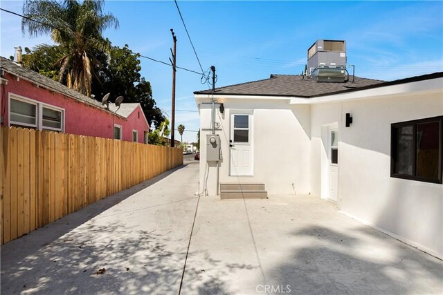 6916 Etiwanda Ave, Reseda, CA 91335 - rear view of property with fence, stucco siding, roof with shingles, and central air condition unit