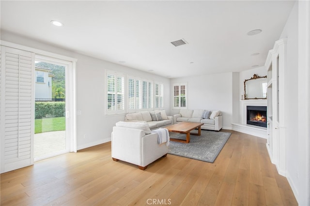 35987 Corte Renata, Murrieta, CA 92562 - living room featuring light wood-style flooring, a warm lit fireplace, healthy amount of natural light, baseboards, and recessed lighting