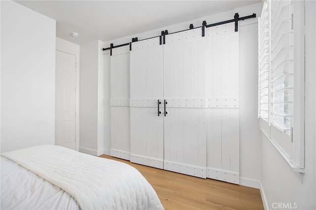 35987 Corte Renata, Murrieta, CA 92562 - bedroom featuring a barn door, wood finished floors, and baseboards