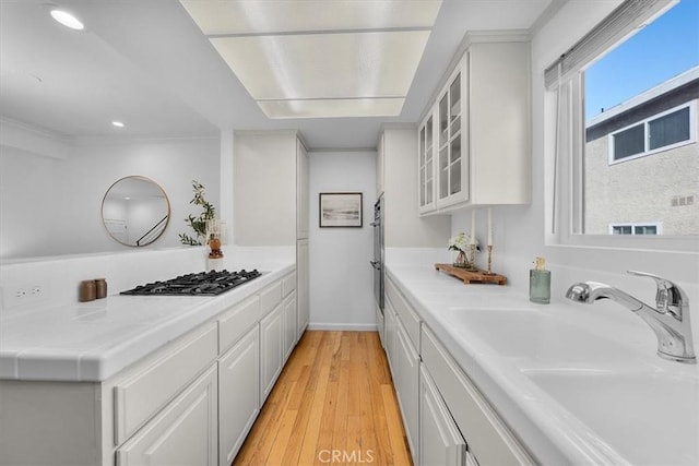 1006 Palm Ln, Redondo Beach, CA 90278 - kitchen featuring a sink, gas stovetop, white cabinetry, light countertops, and light wood-type flooring