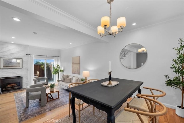 1006 Palm Ln, Redondo Beach, CA 90278 - dining area featuring light wood-style floors, a fireplace, recessed lighting, a chandelier, and crown molding