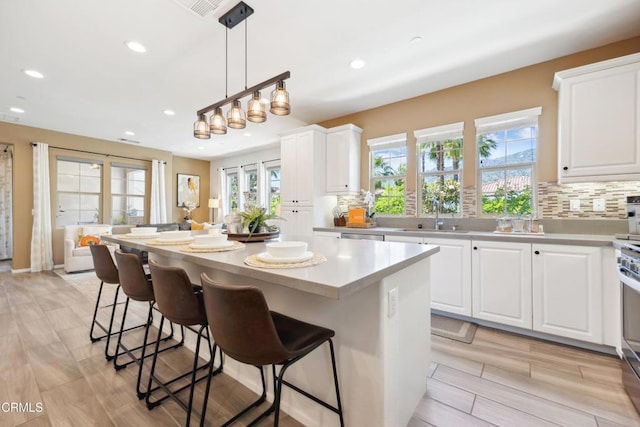 865 Orchid Way Unit A, Azusa, CA 91702 - kitchen featuring recessed lighting, a sink, white cabinets, decorative backsplash, and a kitchen island