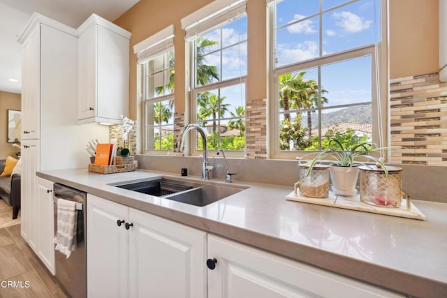 865 Orchid Way Unit A, Azusa, CA 91702 - kitchen with a sink, light countertops, dishwasher, white cabinetry, and decorative backsplash