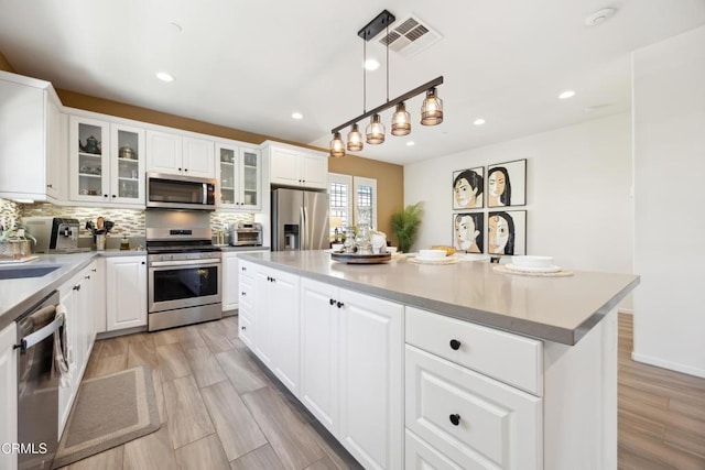 865 Orchid Way Unit A, Azusa, CA 91702 - kitchen featuring appliances with stainless steel finishes, backsplash, recessed lighting, white cabinetry, and pendant lighting