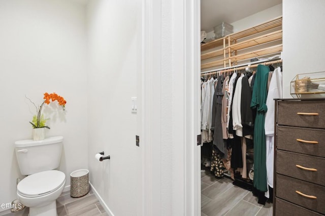 865 Orchid Way Unit A, Azusa, CA 91702 - bathroom with toilet, a spacious closet, and wood finish floors