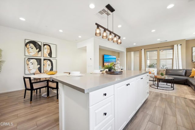 865 Orchid Way Unit A, Azusa, CA 91702 - kitchen featuring white cabinetry, recessed lighting, open floor plan, light countertops, and a kitchen island