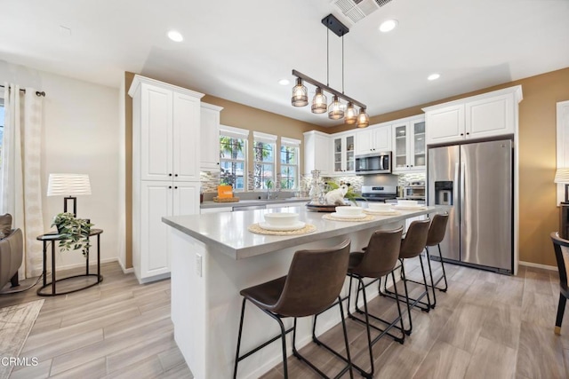 865 Orchid Way Unit A, Azusa, CA 91702 - kitchen featuring stainless steel appliances, light countertops, white cabinetry, a kitchen island, and recessed lighting