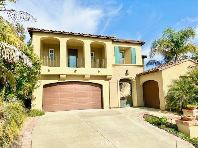 7148 Sitio Caliente, Carlsbad, CA 92009 - mediterranean / spanish house with a balcony, stucco siding, a garage, concrete driveway, and a tiled roof