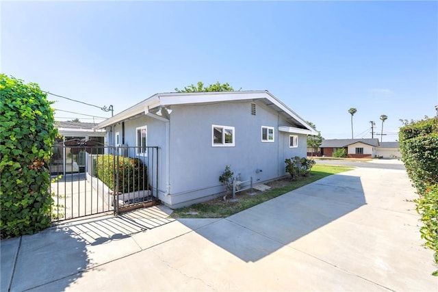 228 W Old Ml, Corona, CA 92882 - view of side of property featuring driveway, stucco siding, and a gate