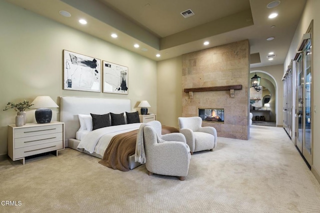 11113 Rocky High Rd, Santa Rosa, CA 93012 - carpeted bedroom featuring recessed lighting, arched walkways, a tiled fireplace, and french doors