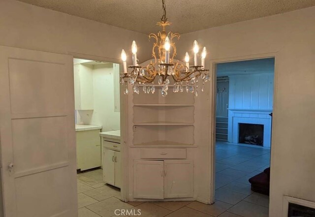 332 W Laurel, Compton, CA 90220 - dining space with light tile patterned flooring, a chandelier, a textured ceiling, and a large fireplace