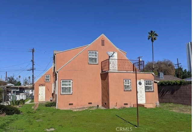 332 W Laurel, Compton, CA 90220 - view of property exterior with crawl space, a balcony, a yard, and stucco siding