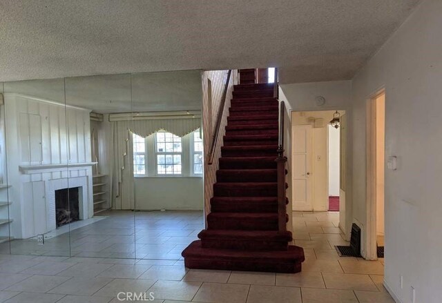 332 W Laurel, Compton, CA 90220 - stairway with a textured ceiling, a fireplace, and tile patterned flooring