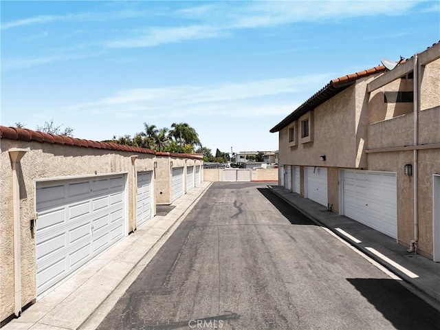 view of asphalt road with community garages