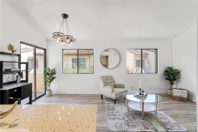 sitting room with a chandelier, wood finished floors, and baseboards