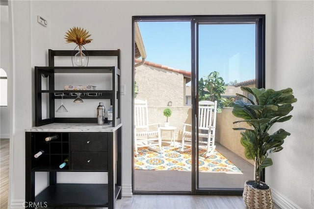 doorway to outside featuring wood finished floors and baseboards