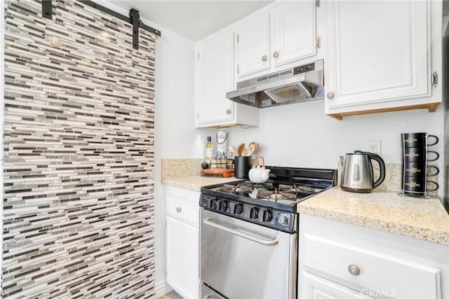 kitchen with under cabinet range hood, stainless steel gas range oven, and white cabinetry