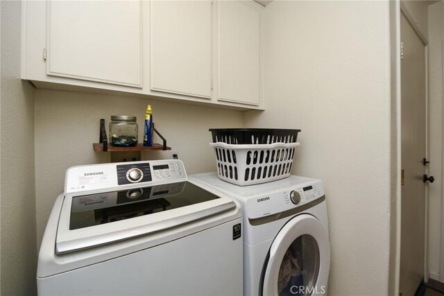1065 Sycamore Ln, San Jacinto, CA 92582 - laundry area featuring washing machine and clothes dryer and cabinet space