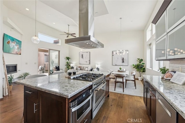 2205 Rockefeller Ln Unit B, Redondo Beach, CA 90278 - kitchen featuring high end stainless steel range, open floor plan, island range hood, a towering ceiling, and dark brown cabinets