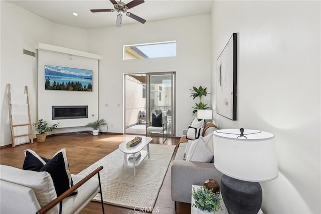 2205 Rockefeller Ln Unit B, Redondo Beach, CA 90278 - living room featuring a glass covered fireplace, wood finished floors, ceiling fan, and a high ceiling