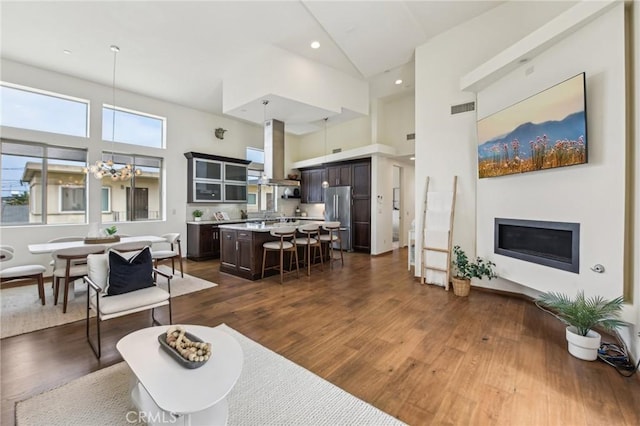 2205 Rockefeller Ln Unit B, Redondo Beach, CA 90278 - living room with high vaulted ceiling, dark wood-style floors, a fireplace, and a chandelier