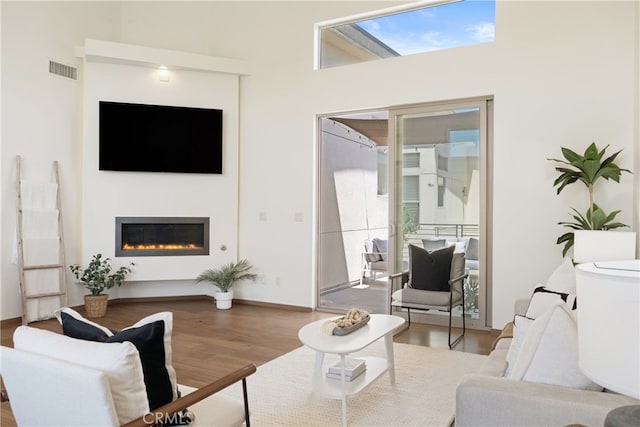 2205 Rockefeller Ln Unit B, Redondo Beach, CA 90278 - living room with wood finished floors, a glass covered fireplace, and a towering ceiling