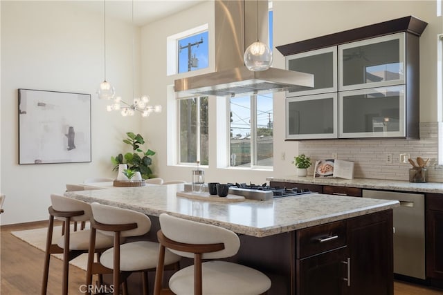 2205 Rockefeller Ln Unit B, Redondo Beach, CA 90278 - kitchen featuring island exhaust hood, stainless steel dishwasher, a center island, a breakfast bar, and wood finished floors