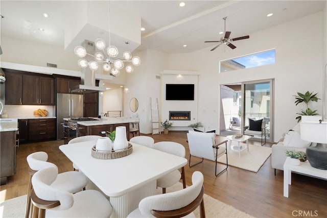 2205 Rockefeller Ln Unit B, Redondo Beach, CA 90278 - dining area with dark wood-style flooring, a towering ceiling, ceiling fan, a glass covered fireplace, and recessed lighting
