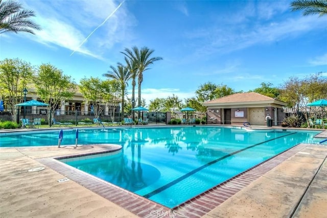 community pool with fence and a patio area