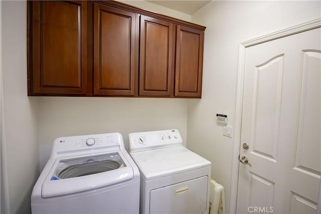 laundry area featuring separate washer and dryer and cabinet space